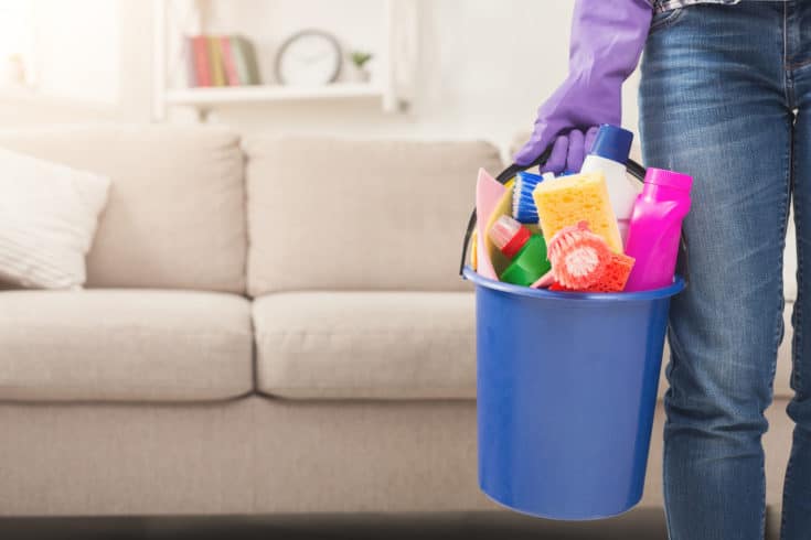 Unrecognizable woman with cleaning equipment ready to clean house. 